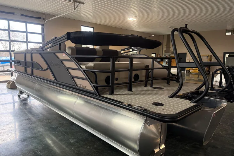 Slide: The Image of 2026 Bentley Pontoons 253 Elite Swingback Dual Capt EXT in showroom, sleek design, luxury features. - 5