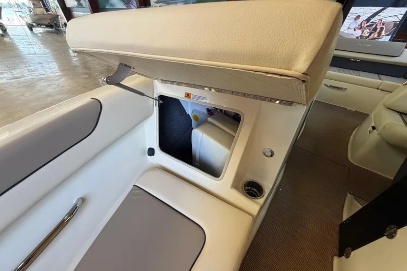 Slide: The Image of 2027 Chris-Craft Sportster 25 interior storage compartment with beige seating and modern design. - 38