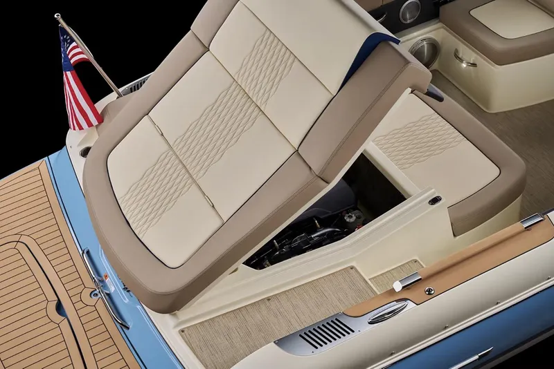 Slide: The Image of Manufacturer Provided Image: 2025 Chris-Craft Sportster 25 boat interior with beige seating and American flag. - 10