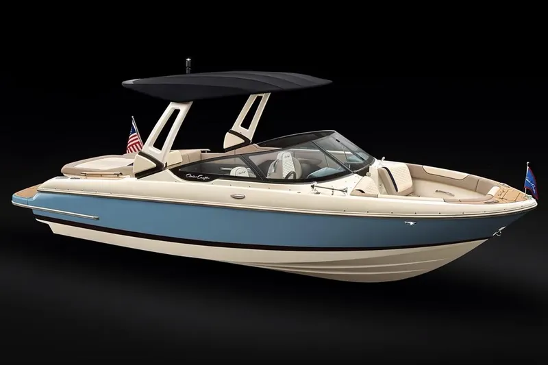 Slide: The Image of Manufacturer Provided Image: 2025 Chris-Craft Sportster 25 boat with blue and white exterior, black canopy, and American flag. - 14