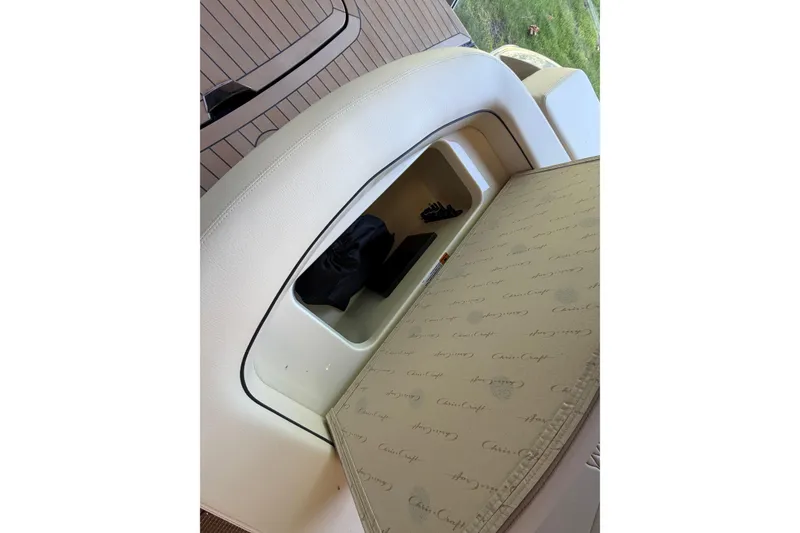 Slide: The Image of 2027 Chris-Craft Sportster 25 boat interior storage compartment with branded cushion. - 29