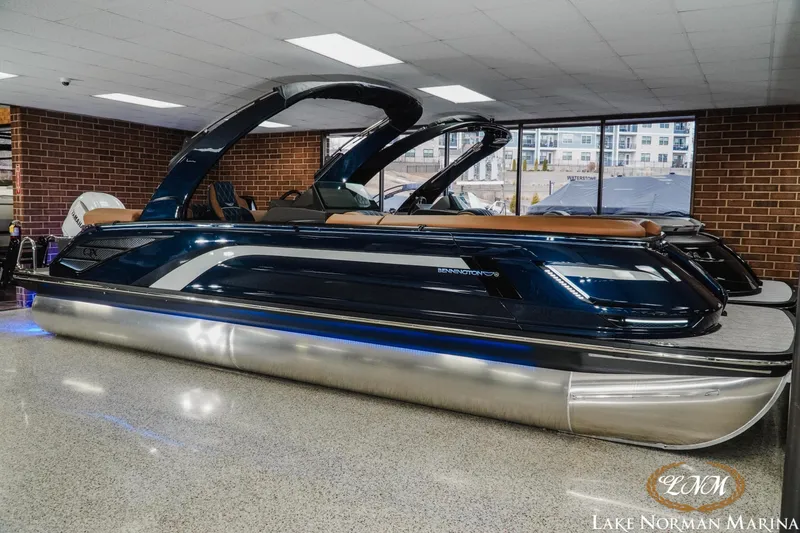 Slide: The Image of 2026 Bennington 25QXFBA pontoon boat displayed indoors at Lake Norman Marina. - 5