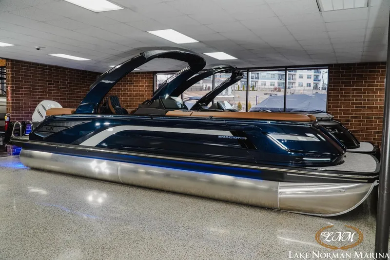 Slide: The Image of 2026 Bennington 25QXFBA pontoon boat displayed indoors at Lake Norman Marina. - 6