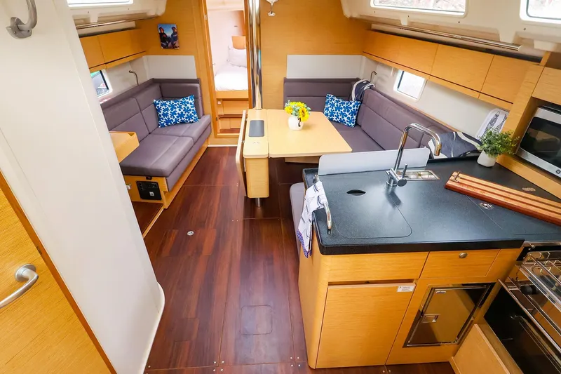 Slide: The Image of Interior of a 2019 Hanse 418 yacht featuring a modern kitchen and cozy seating area. - 22