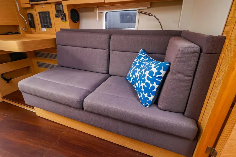 Slide: The Image of Interior of 2019 Hanse 418 yacht with gray sofa and blue-patterned pillow. - 28
