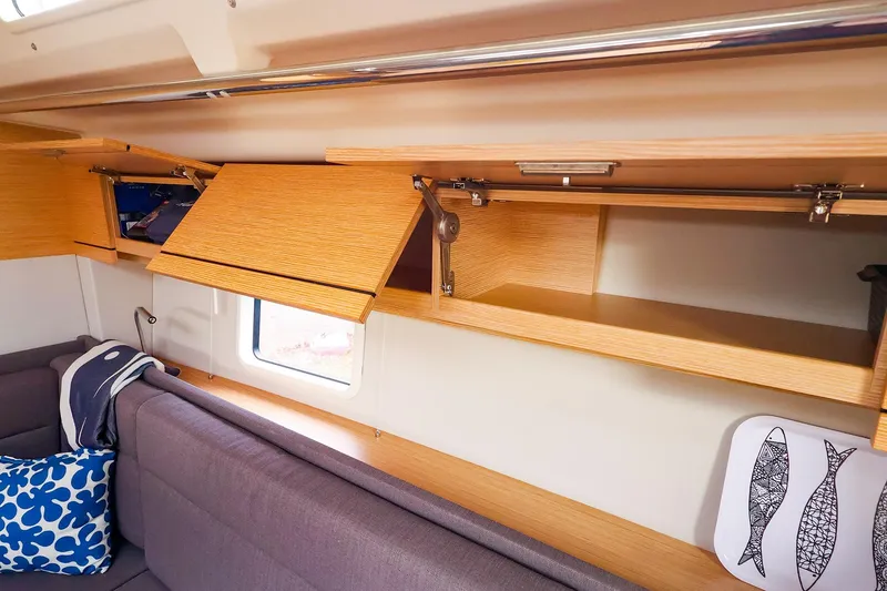 Slide: The Image of Interior of 2019 Hanse 418 yacht with open wooden cabinets and cozy seating area. - 37