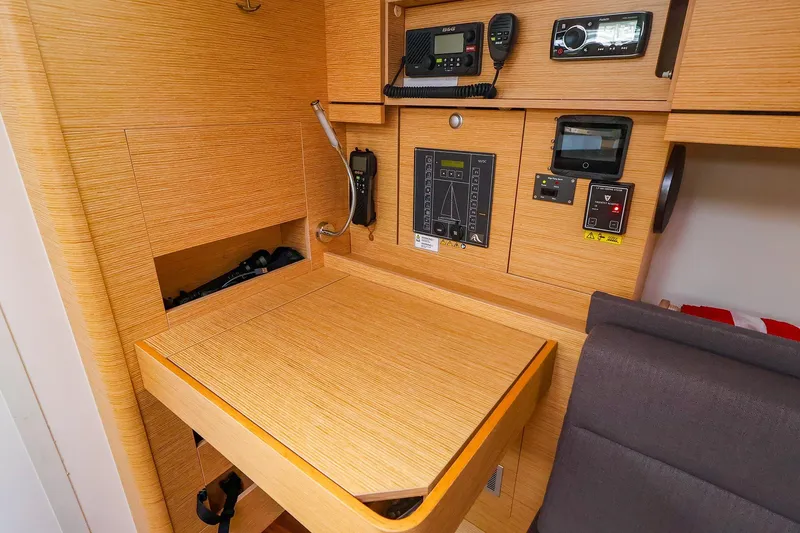 Slide: The Image of Navigation station inside 2019 Hanse 418 yacht with control panels and communication equipment. - 39