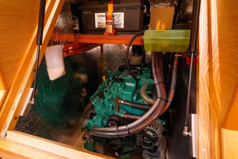 Slide: The Image of Engine compartment of a 2019 Hanse 418 sailboat, featuring a green engine and battery. - 49