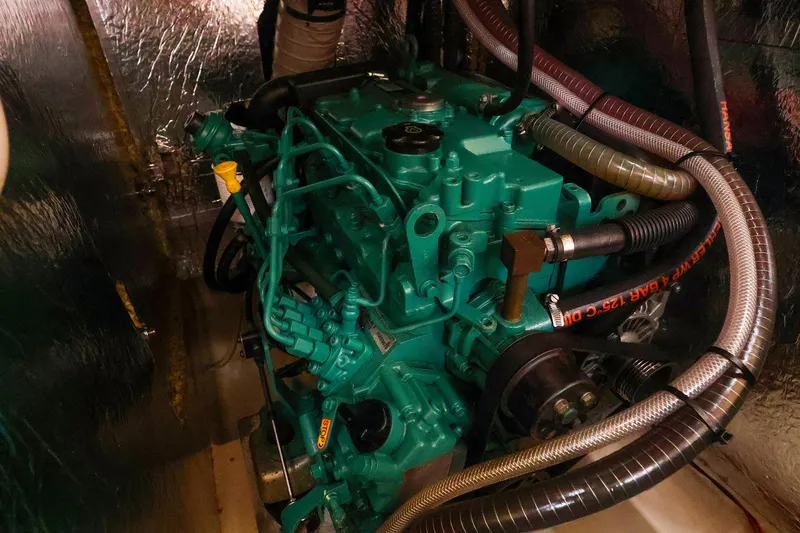 Slide: The Image of Engine compartment of a 2019 Hanse 418 yacht, showcasing intricate machinery and hoses. - 50