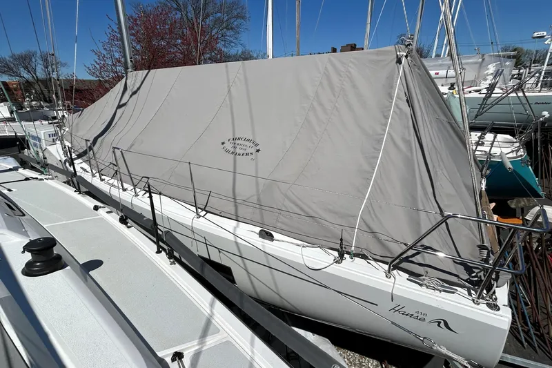 Slide: The Image of 2019 Hanse 418 sailboat covered with a protective tarp in a marina. - 56