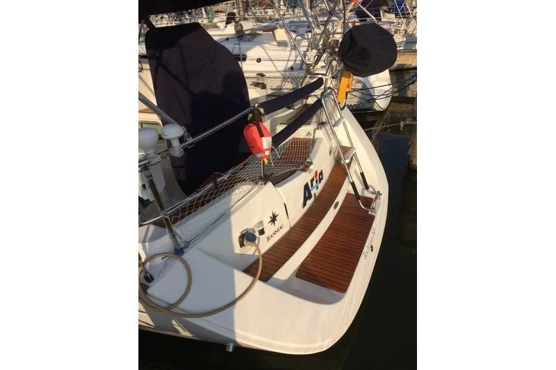 Slide: The Image of 2007 Jeanneau Sun Odyssey 36i sailboat docked, featuring a wooden deck and safety equipment. - 11