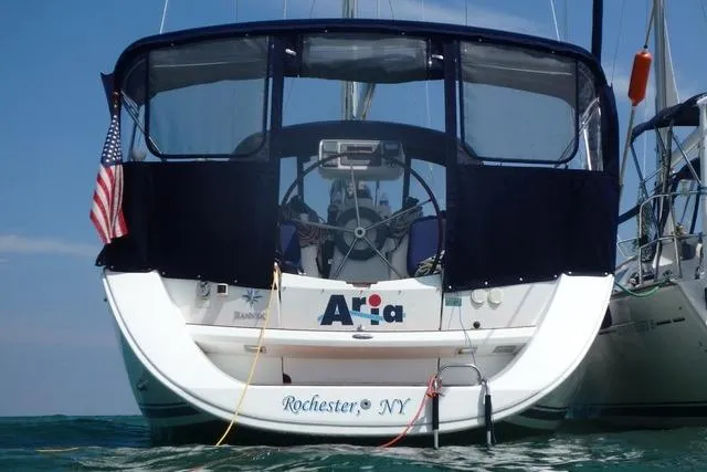 Slide: The Image of 2007 Jeanneau Sun Odyssey 36i sailboat docked, featuring a covered cockpit and American flag. - 8