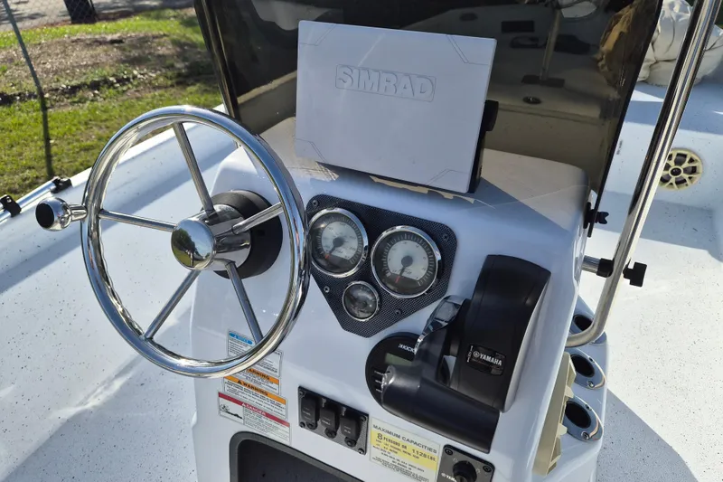 Slide: The Image of 2021 Xpress XP20CC boat console with steering wheel, gauges, and Simrad display. - 11