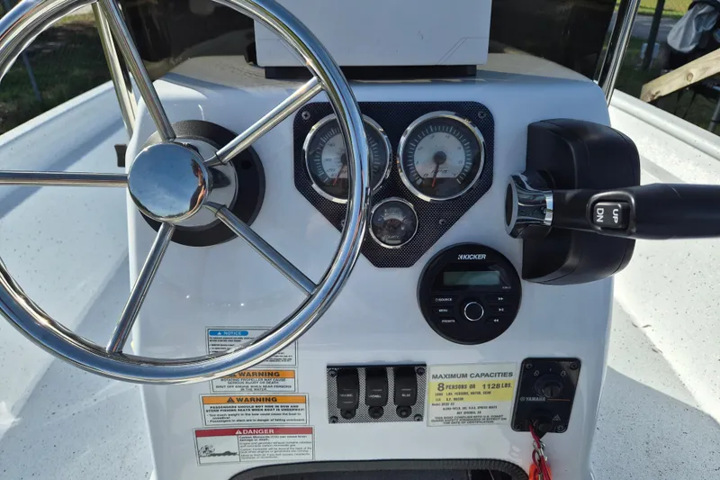 Slide: The Image of 2021 Xpress XP20CC boat dashboard with steering wheel, gauges, and controls. - 13