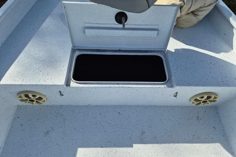 Slide: The Image of 2021 Xpress XP20CC boat storage compartment with open lid and speakers. - 18