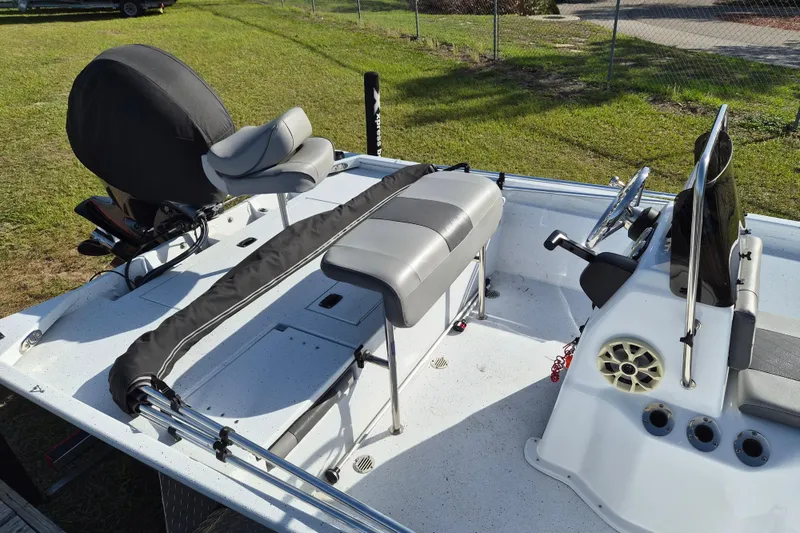 Slide: The Image of 2021 Xpress XP20CC boat interior with seating and steering wheel, parked on grass. - 6