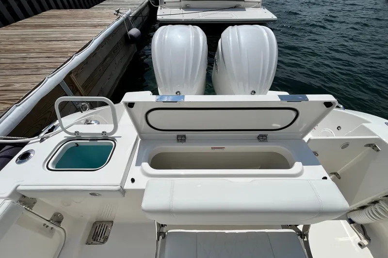 Slide: The Image of 2027 Pursuit DC 326 Dual Console boat with open storage compartments at the dock. - 11