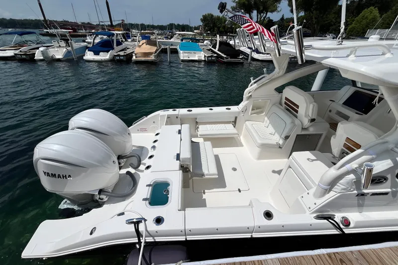Slide: The Image of 2027 Pursuit DC 326 Dual Console boat docked, featuring twin Yamaha engines. - 12