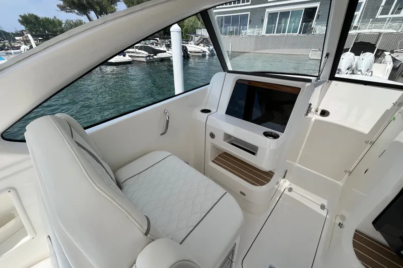 Slide: The Image of Interior of 2027 Pursuit DC 326 Dual Console boat with white seating and dashboard. - 2
