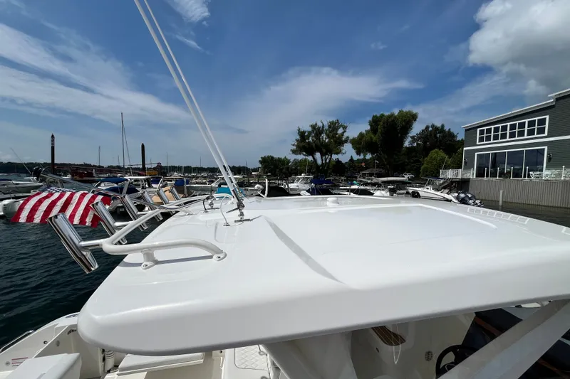 Slide: The Image of 2027 Pursuit DC 326 Dual Console boat docked at marina under clear blue sky. - 13