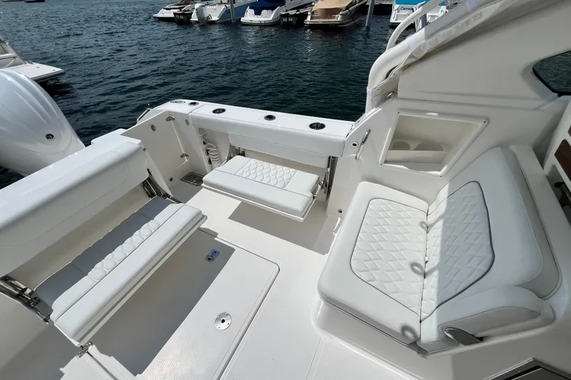 Slide: The Image of 2027 Pursuit DC 326 Dual Console boat interior with white seating and water view. - 10