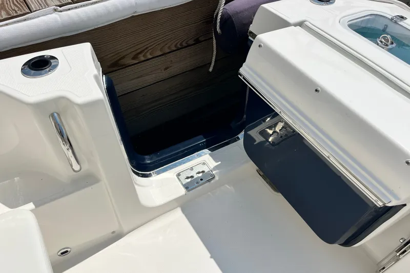 Slide: The Image of 2027 Pursuit DC 326 Dual Console boat interior with storage compartment and seating area. - 8
