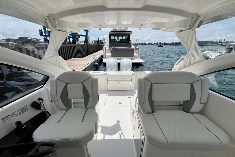 Slide: The Image of 2027 Pursuit DC 326 Dual Console boat interior with luxurious seating and waterfront view. - 4