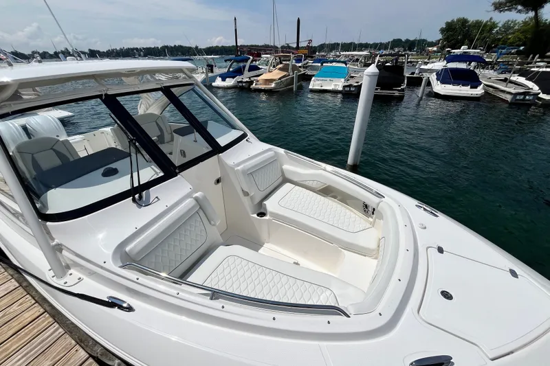 The Image of 2027 Pursuit DC 326 Dual Console boat docked at marina, featuring spacious seating and sleek design. - 0
