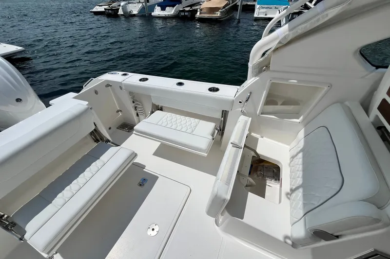 Slide: The Image of 2027 Pursuit DC 326 Dual Console boat interior with white seating and storage compartments. - 9
