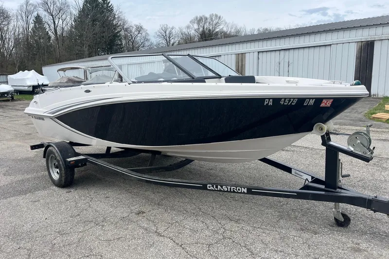 Slide: The Image of 2014 Glastron GT 185 boat on trailer, parked outdoors near storage facility. - 3