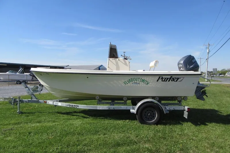 Slide: The Image of 2003 Parker 1801 Center Console boat on trailer, parked on grass under clear sky. - 2