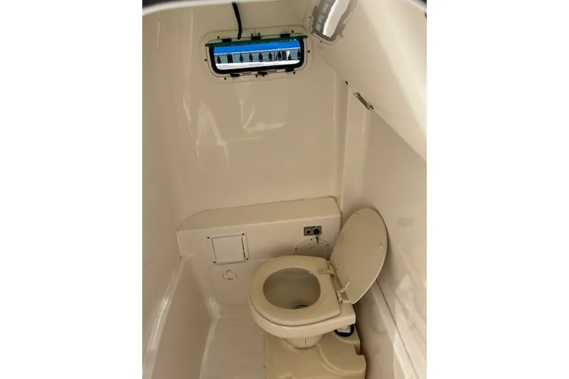 Slide: The Image of 2007 Everglades 240 Center Console boat interior with toilet and small window. - 16