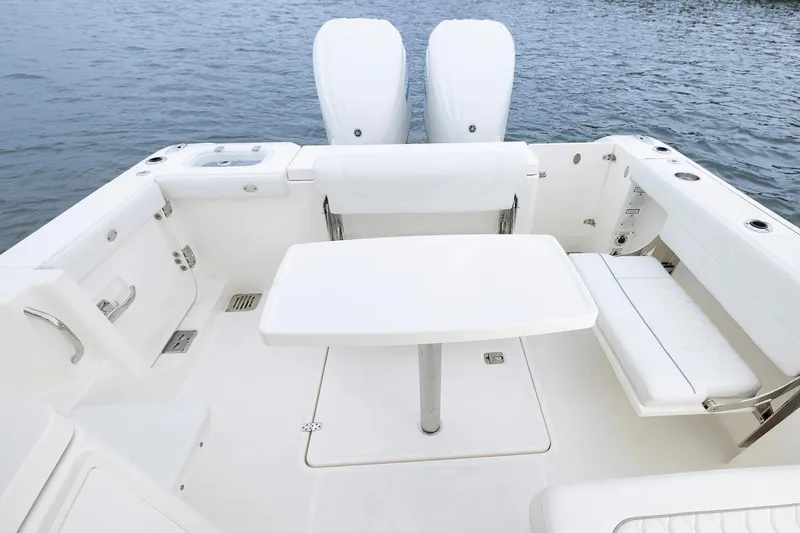 Slide: The Image of Manufacturer Provided Image: 2026 Pursuit DC 286 Dual Console boat interior with seating and table on water. - 13