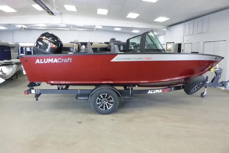 The Image of 2024 Alumacraft Competitor FSX 175 boat in showroom, red exterior, on trailer. - 1