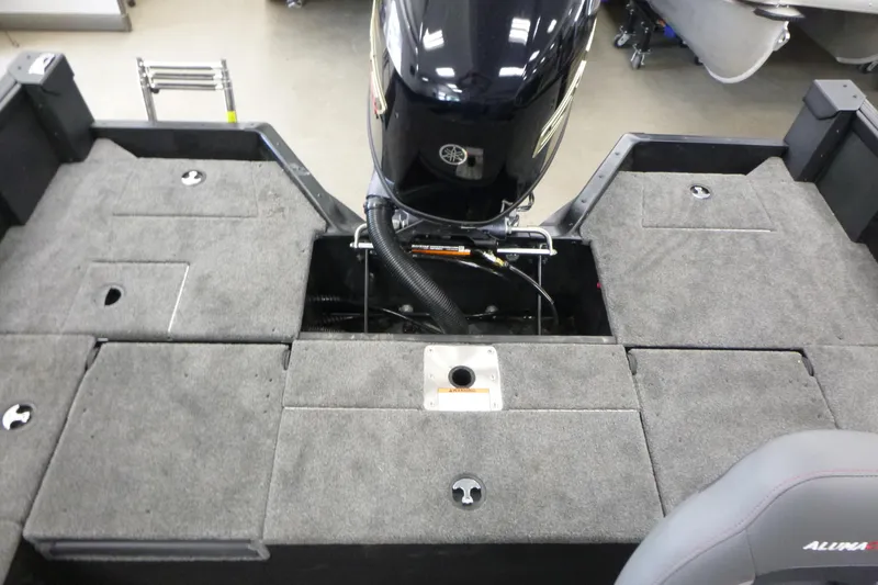 Slide: The Image of 2024 Alumacraft Competitor FSX 175 boat interior with motor and carpeted deck. - 11