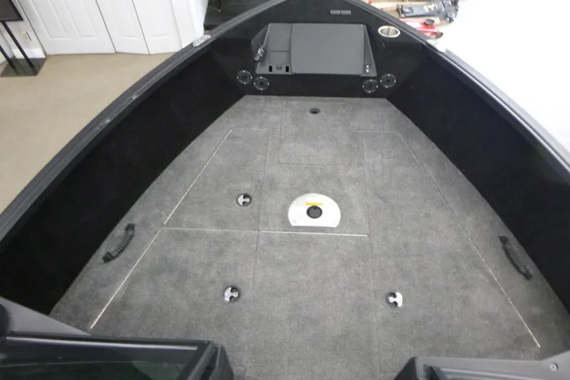 Slide: The Image of 2024 Alumacraft Competitor FSX 175 boat interior with carpeted deck and storage compartments. - 6