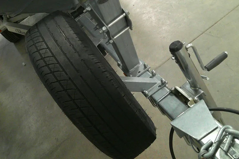 Slide: The Image of Trailer wheel and hitch of a 2023 Tahoe T21 on concrete floor. - 16