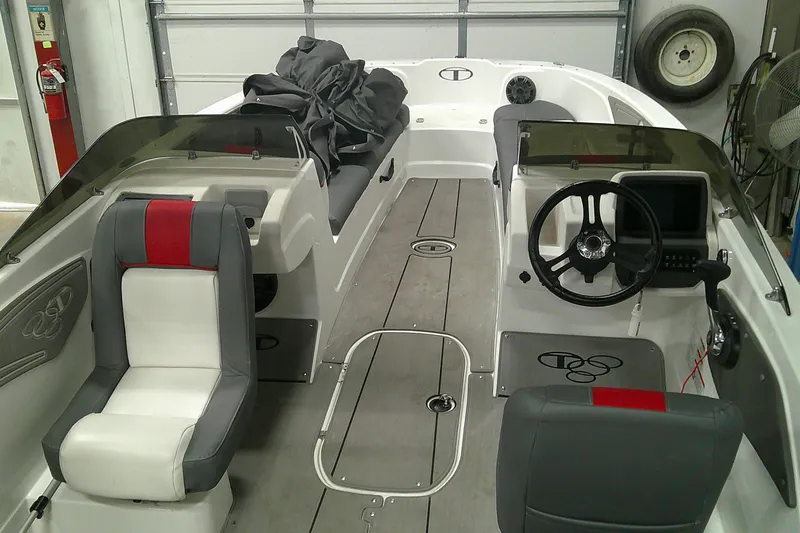 Slide: The Image of 2023 Tahoe T21 boat interior with steering wheel, seating, and dashboard in a garage setting. - 6