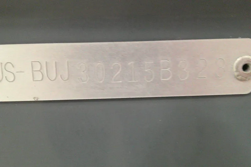 Slide: The Image of Metallic identification plate with engraved code "US-BUJ30215B323" on a Tahoe T21, 2023 model. - 7