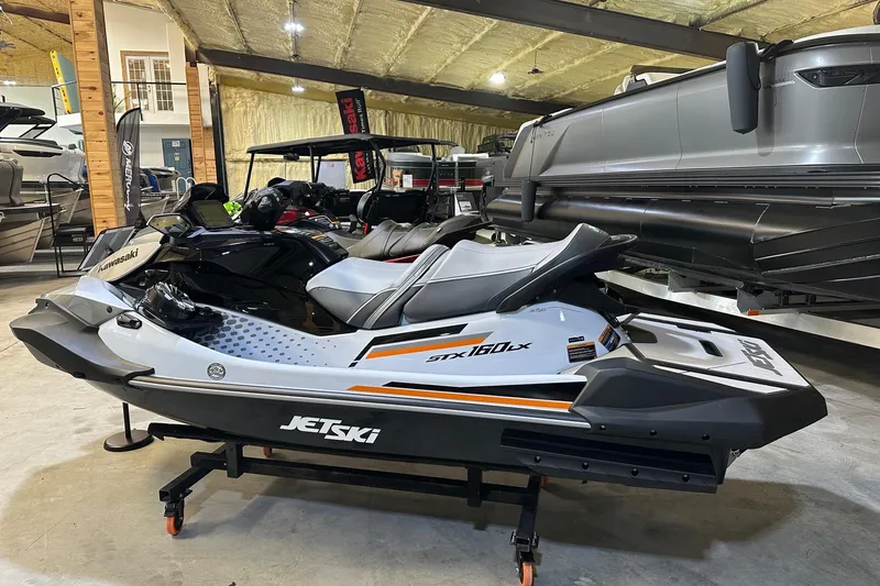 Slide: The Image of 2026 Kawasaki Jet Ski STX on display in a showroom, featuring sleek design and modern features. - 2