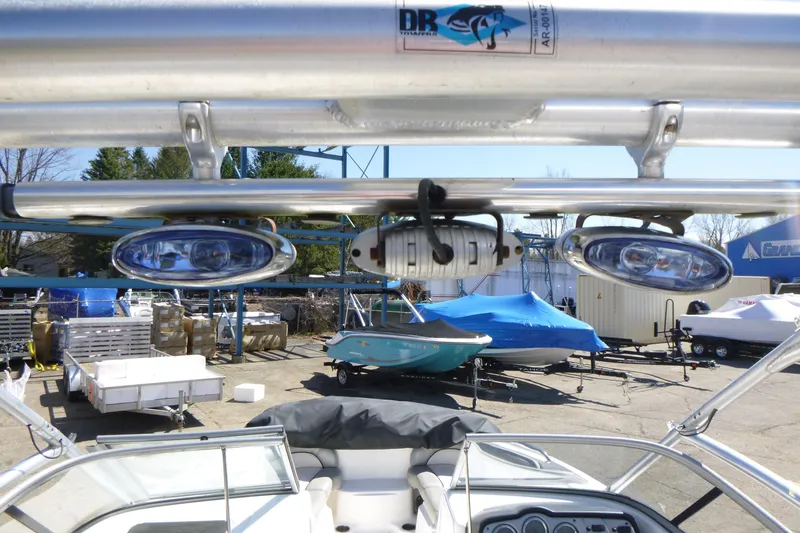 Slide: The Image of 2011 Yamaha Boats AR240 HO with mounted lights, parked in a marina. - 13