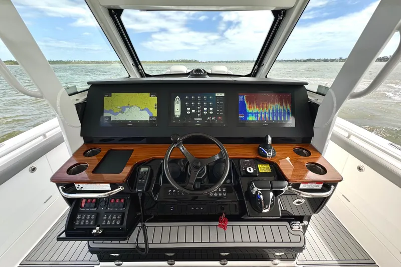 Slide: The Image of 2023 Everglades 395 Center Console helm with advanced navigation displays and controls. - 12