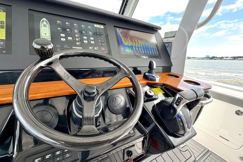Slide: The Image of 2023 Everglades 395 Center Console helm with advanced navigation displays and controls. - 13