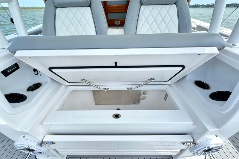 Slide: The Image of 2023 Everglades 395 Center Console boat with open storage compartment and cushioned seating. - 19