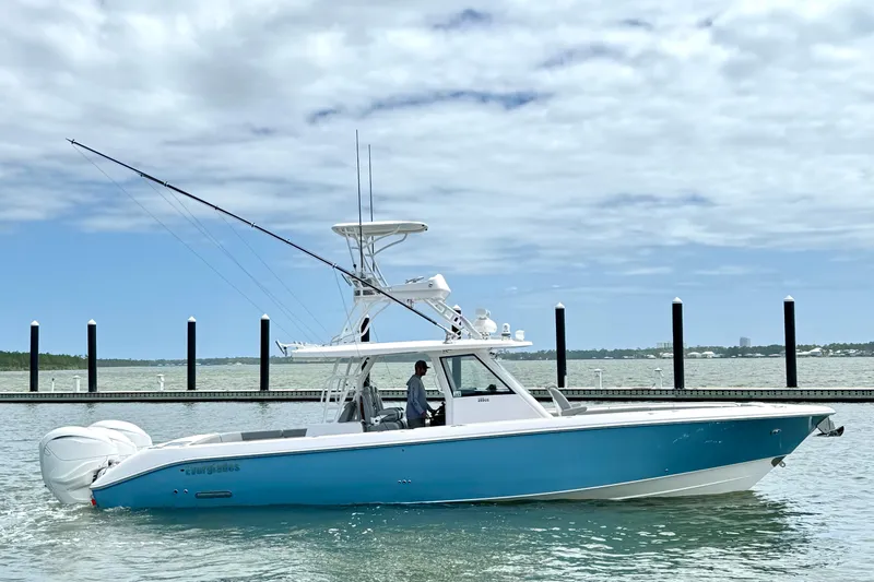 Slide: The Image of 2023 Everglades 395 Center Console boat on water, clear sky background. - 2