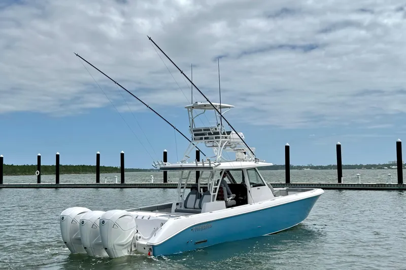 Slide: The Image of 2023 Everglades 395 Center Console boat with triple engines on a calm waterway. - 3