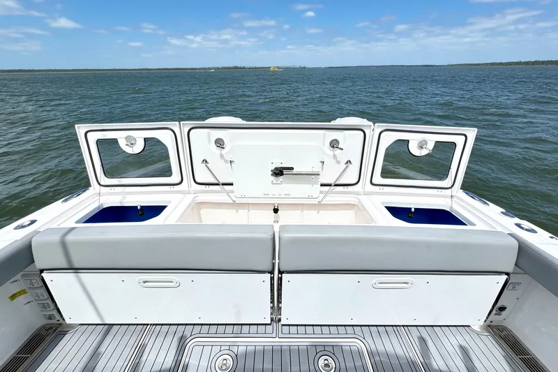 Slide: The Image of 2023 Everglades 395 Center Console boat interior with open storage compartments on a sunny day. - 30