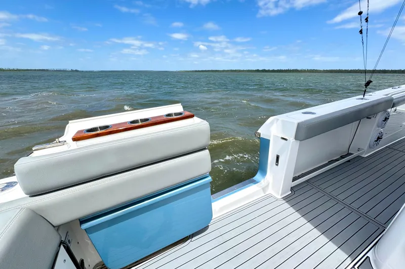 Slide: The Image of 2023 Everglades 395 Center Console boat on open water, featuring sleek seating and cup holders. - 45