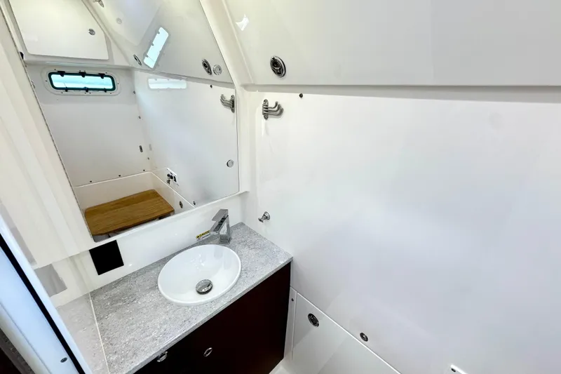 Slide: The Image of Modern bathroom interior of 2023 Everglades 395 Center Console boat, featuring sleek sink and mirror. - 46