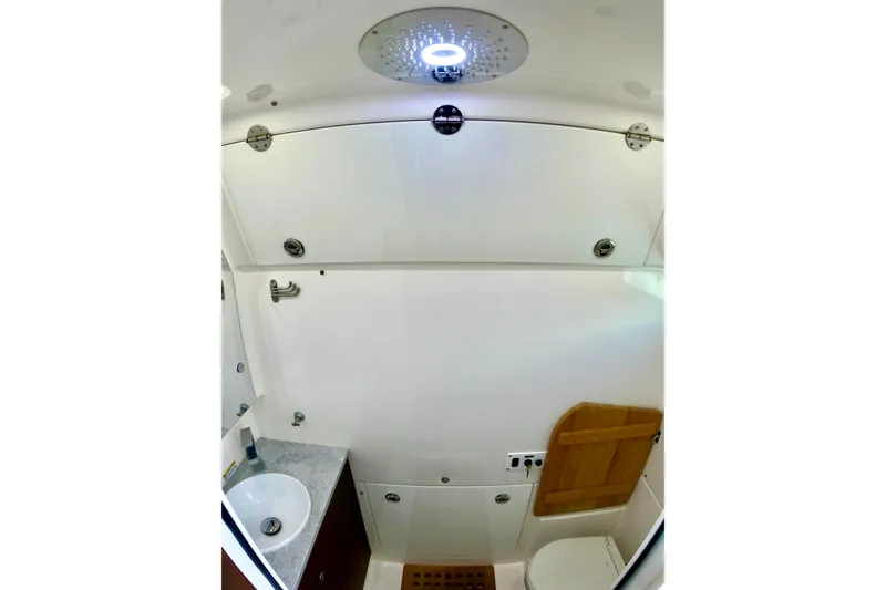 Slide: The Image of 2023 Everglades 395 Center Console bathroom interior with modern fixtures and wooden accents. - 47